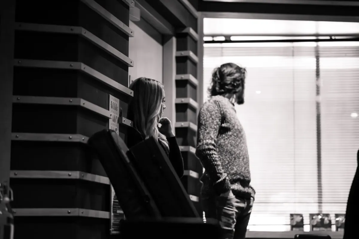 A candid black and white photo capturing thoughtful moments in a music studio.