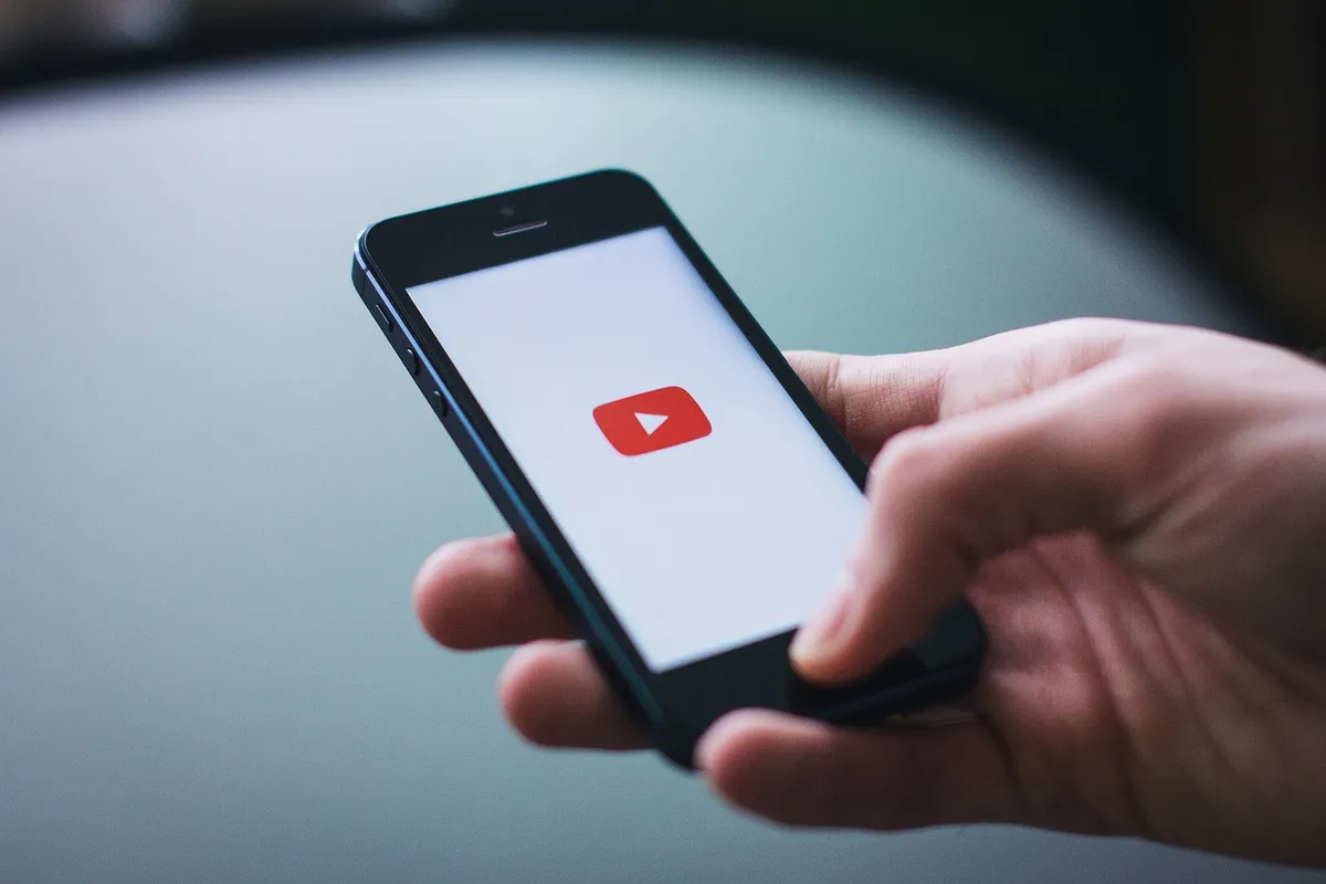 木製字母棋子拼出「YOUTUBE」於木製表面，象徵視頻分享與流媒體