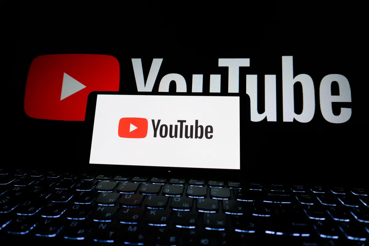 電腦螢幕上顯示YouTube標誌的特寫，背景為黑暗環境。