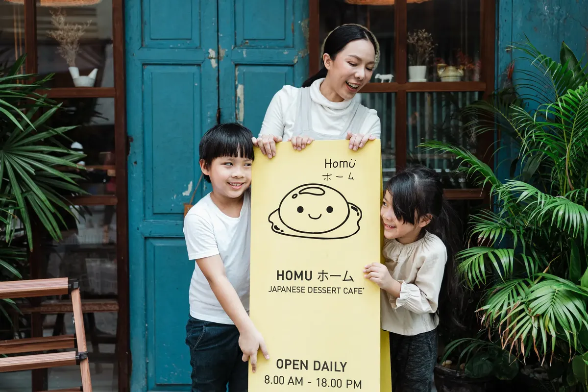 A mother and children enjoying a moment at a Japanese dessert café with a cheerful sign.