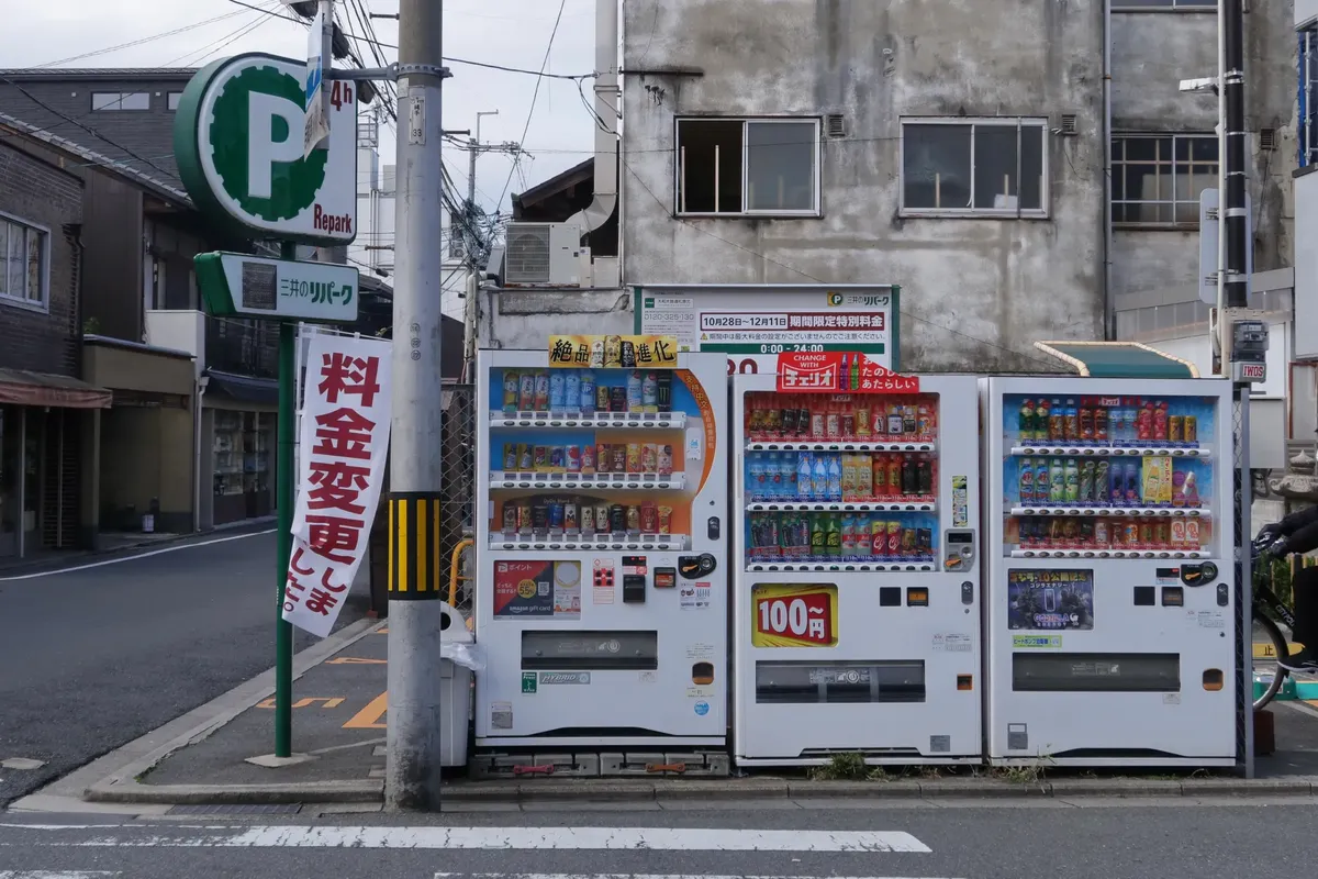 Vending machines in a Japanese street offering beverages, highlighting urban convenience.