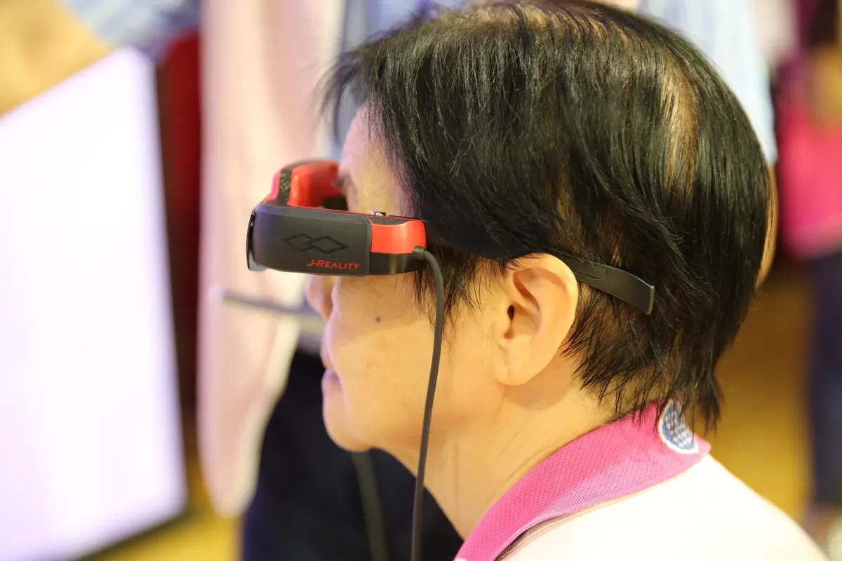 Adult engaged with virtual reality headset indoors at a technology event.